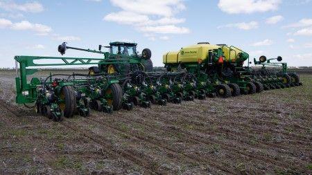 24-row 1775NT Planter on tracks being pulled by an 8410RX model