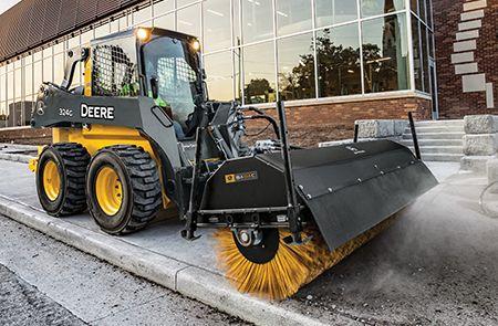 John Deere 324 G-Tier equipped with an angle broom