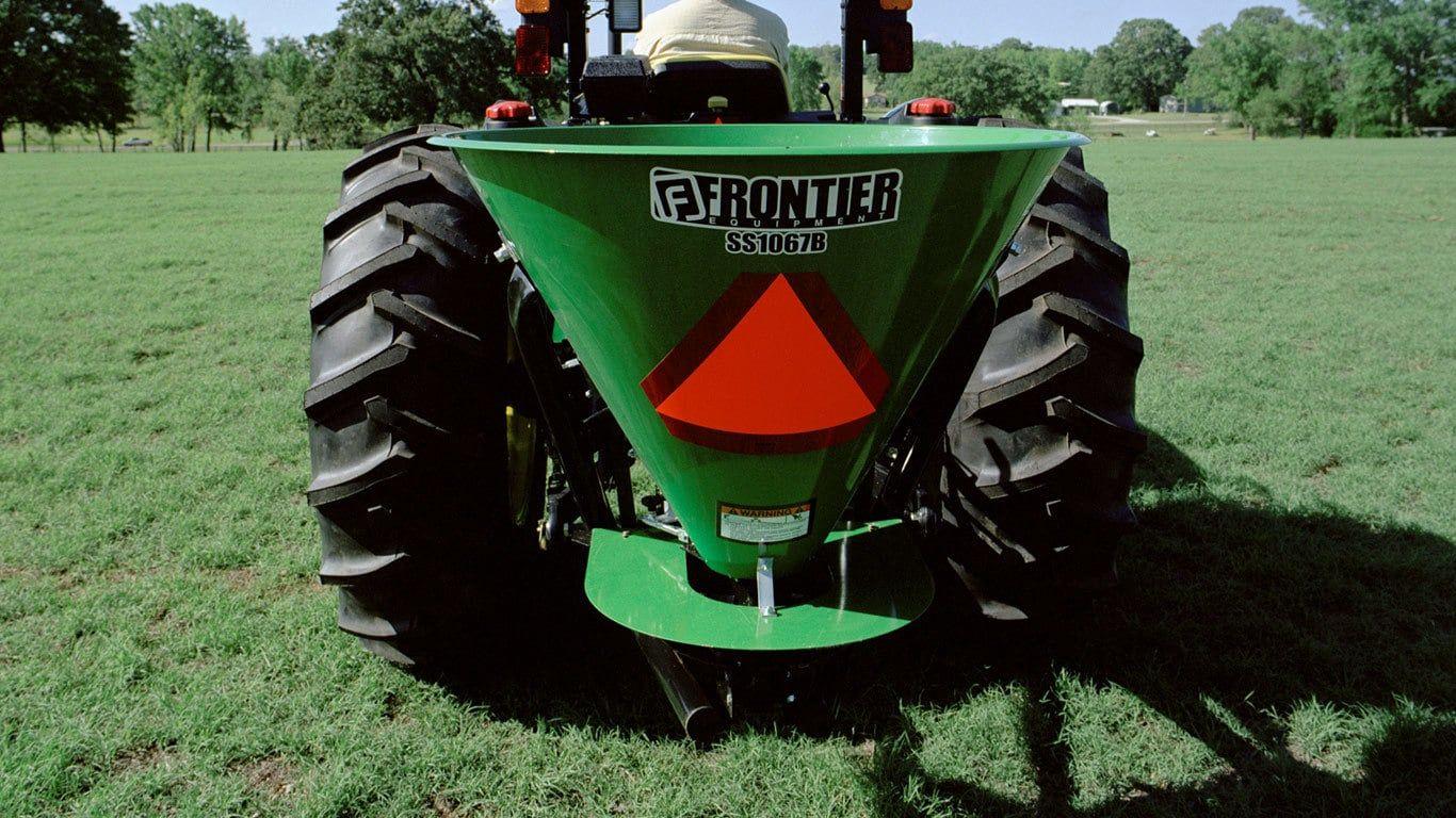 Field image of SS1067B broadcast spreader attached to rear of Tractor
