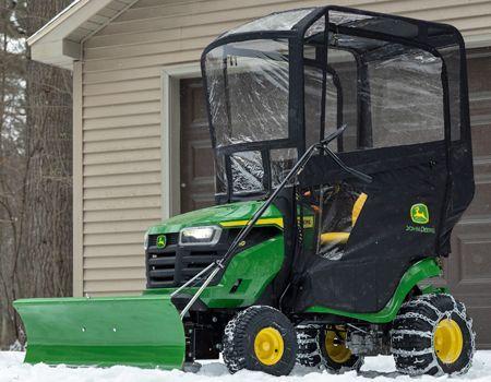 S140 Tractor with front blade, weather enclosure, weights, and tire chains