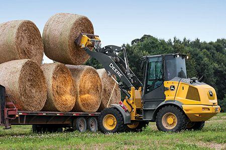 Loader moving hay bales