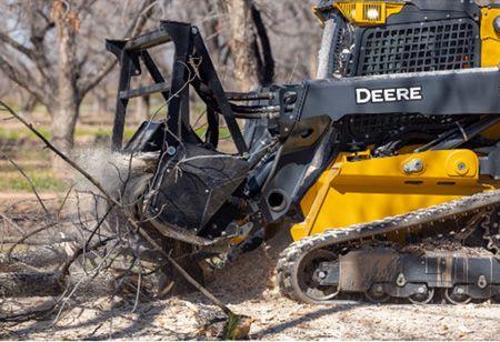 MK76 on a 335 P-Tier CTL mulching a pile of vegetation.