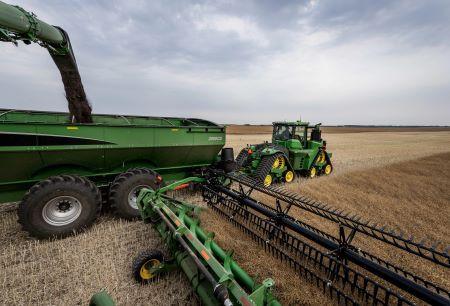 S Series Combine with Hinged Draper header unloading on-the-go