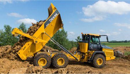310E dumping the bin in a dirt pile.