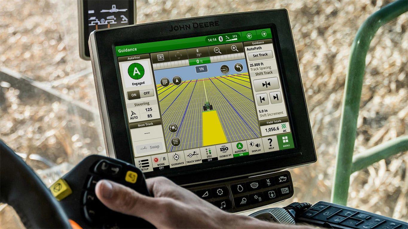 Close-up of a John Deere tractor's guidance system screen showing navigation and field data.