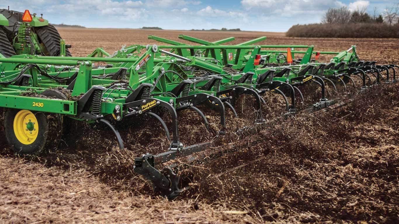 2430 Chisel Plow in field, showcasing robust frame and rear rolling basket.